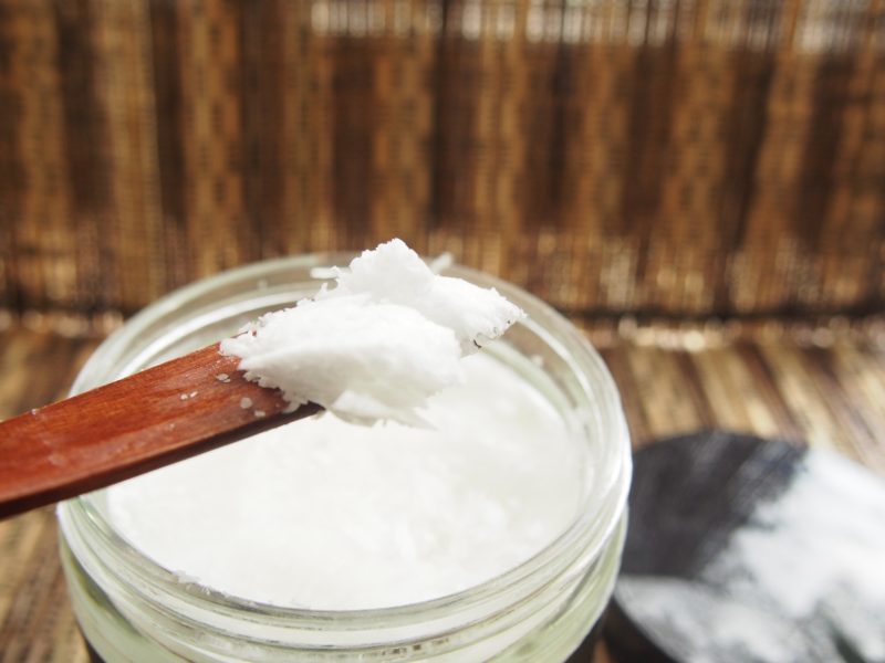 coconut oil is taken in a spoon for cooking and for other uses